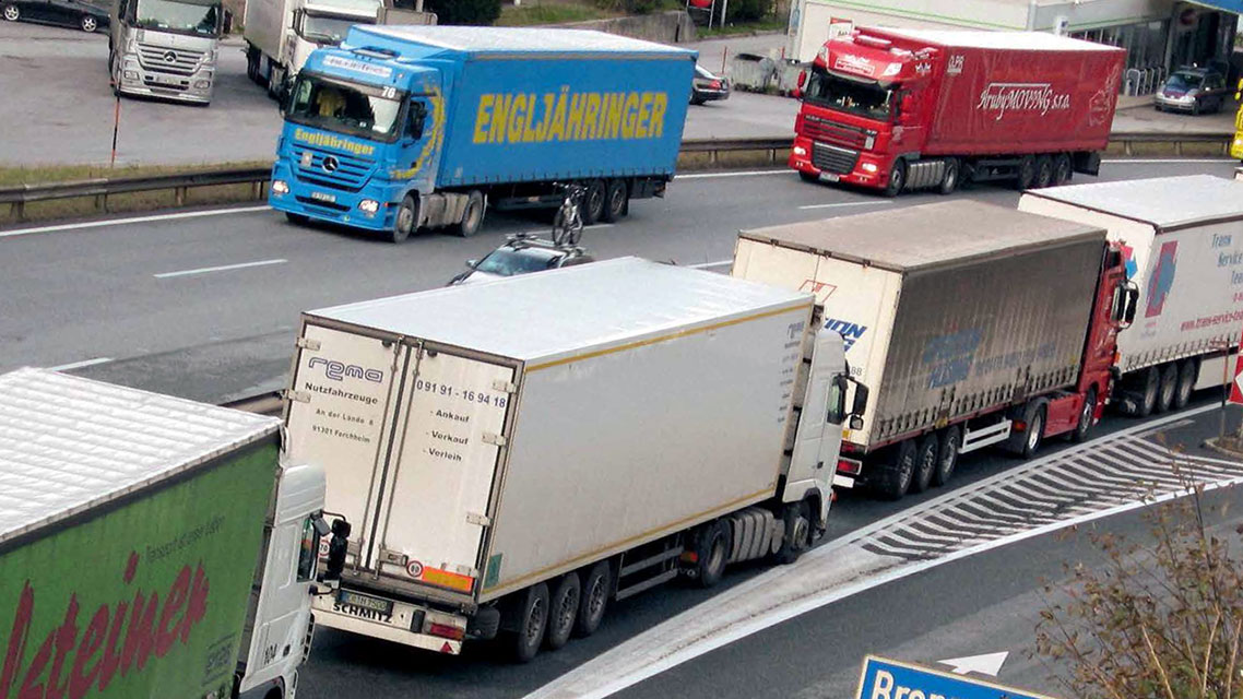 Eine Gruppe von Lastwagen auf einer Autobahn.