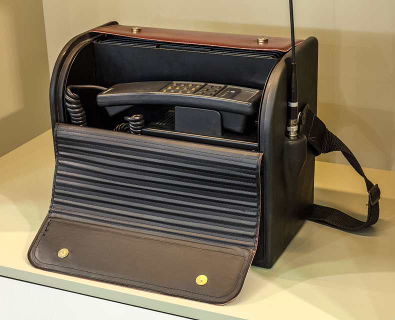 Ein Smartphone in einer Schutzhülle liegt auf einem Koffer.