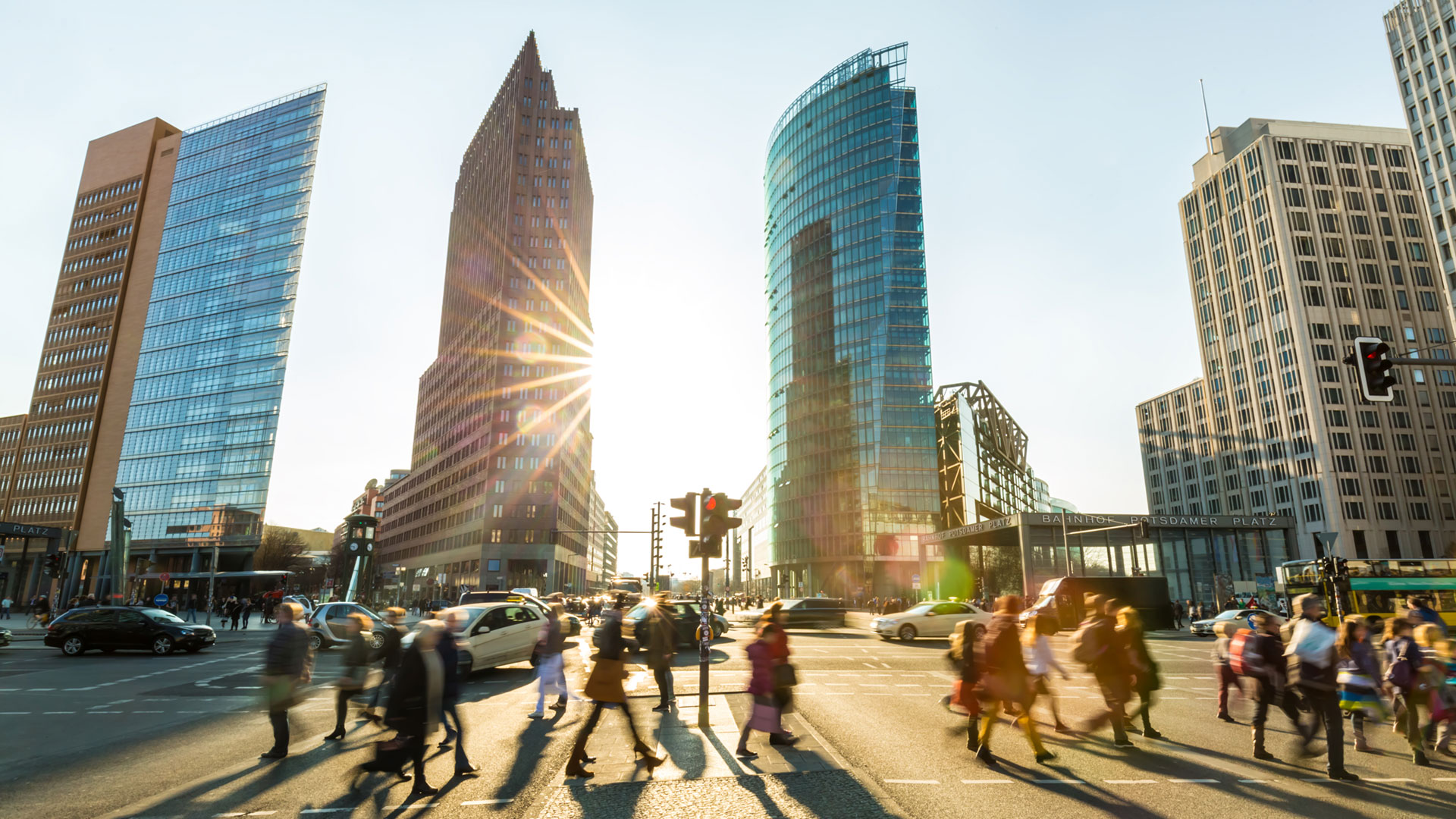 Eine Gruppe von Menschen überquert eine Straße vor hohen Gebäuden.