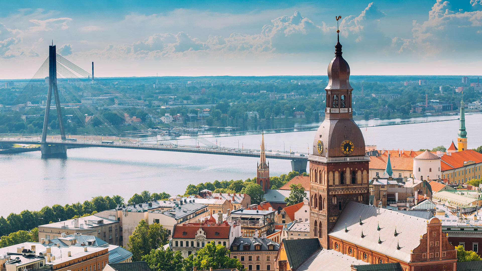 © Kapsch TrafficCom Stadt mit Fluss und Brücke im Vordergrund, bewölkter Himmel.