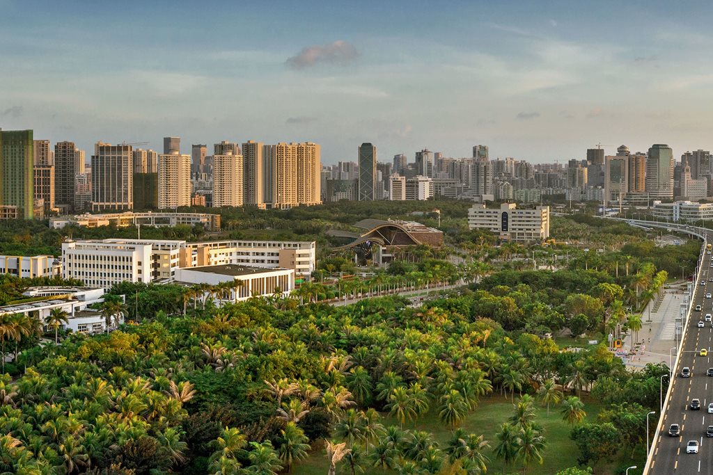 Stadtansicht mit Bäumen und Gebäuden im Vordergrund.