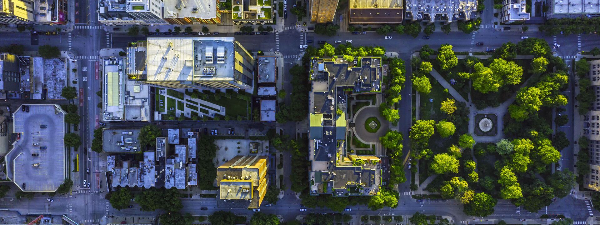 Vista aérea de una ciudad con numerosos edificios y árboles, destacando la integración urbana y el entorno natural.
